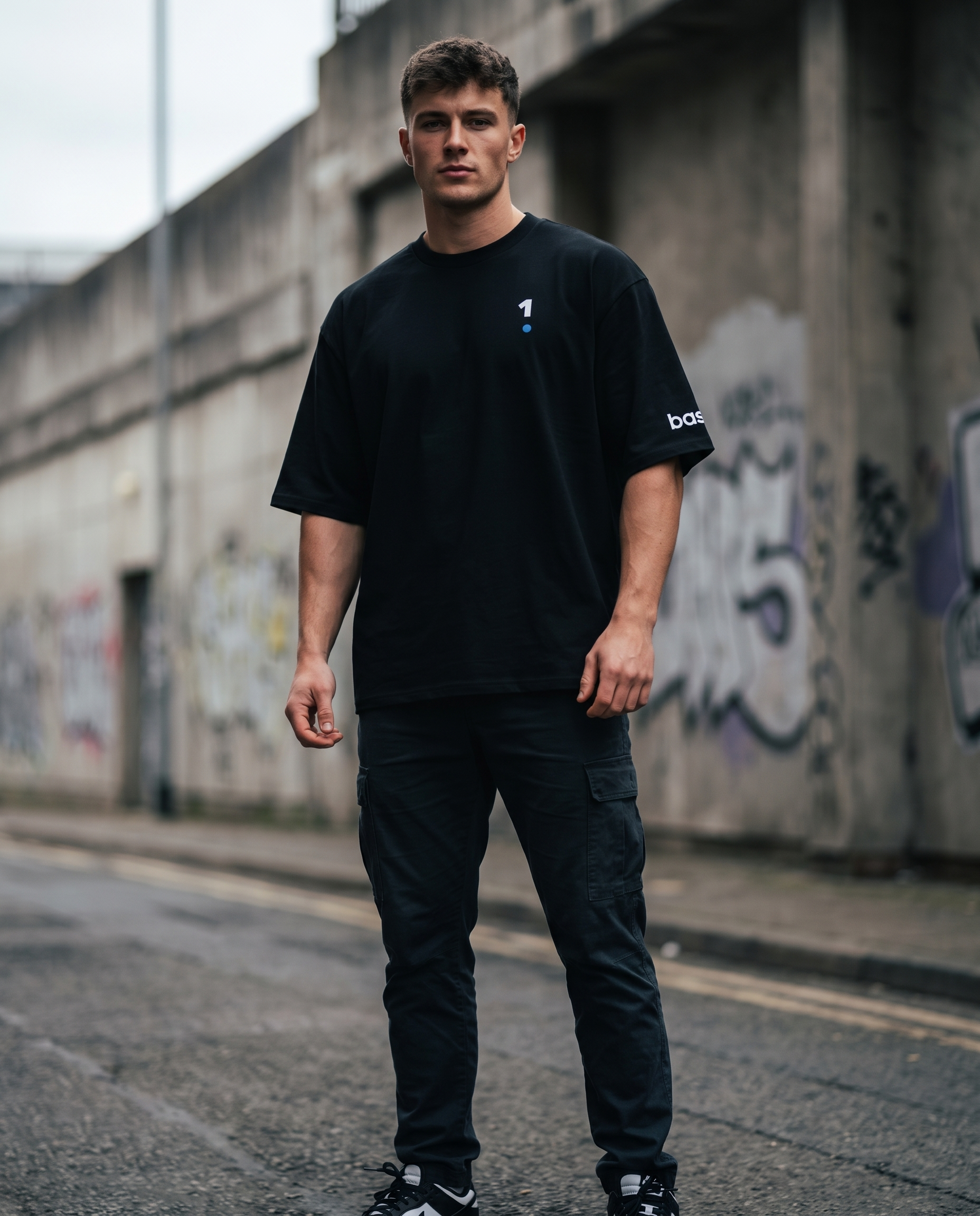 Man wearing Base1 Logo Oversized Heavyweight Tee on a city street