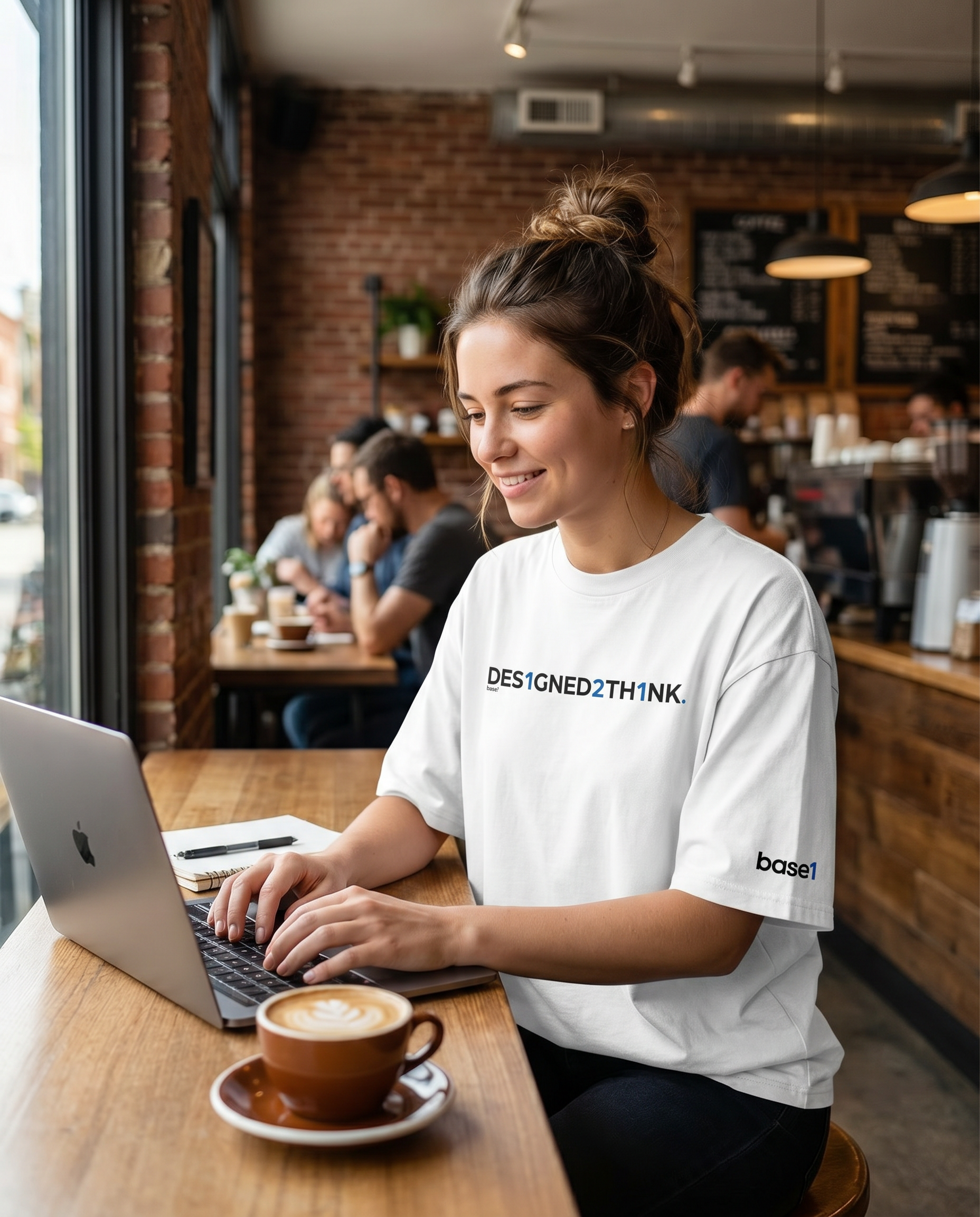 Woman wearing Base1 Designed2Think oversized heavyweight t-shirt working in a cafe