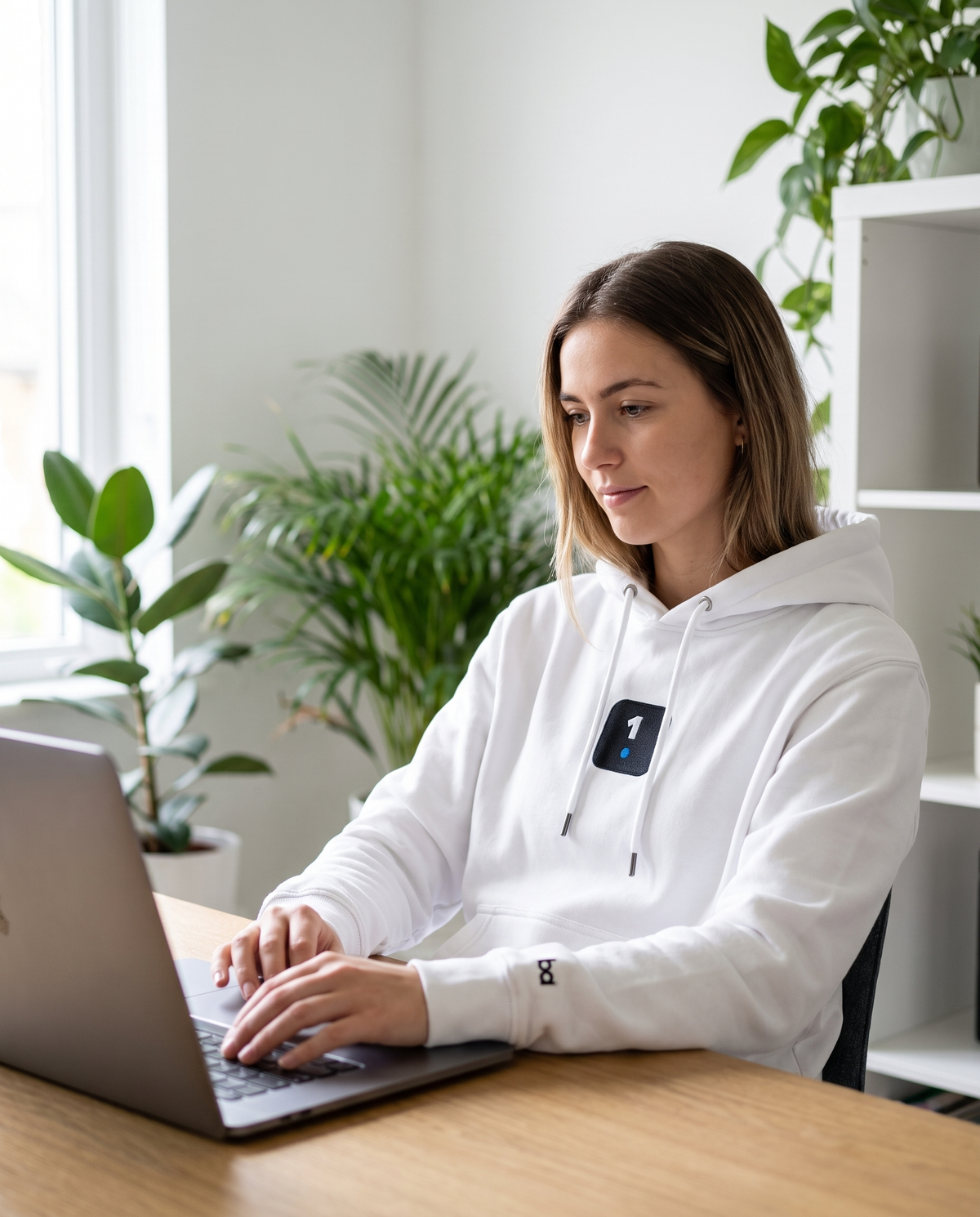 Woman wearing 1 Icon Logo Premium eco hoodie working from home