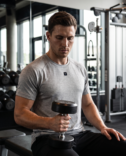 Man wearing Base1 Active 1 Icon Logo Performance T-Shirt in a modern gym