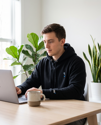 Man wearing Base1 Logo Unisex Hoodie working from home
