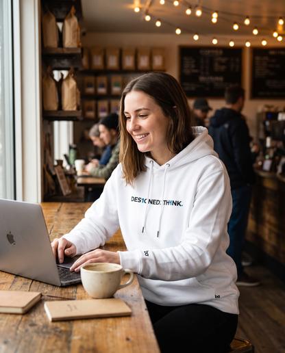 Woman wearing DESIGNED2THINK Eco Hoodie in a cafe